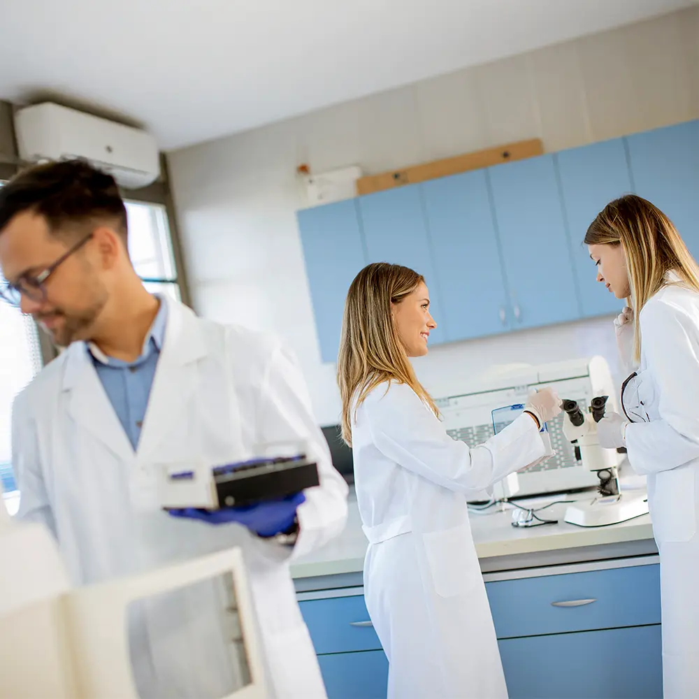 3 personnes dans un laboratoire qui sont entrain d'étudier les produits Superlooong